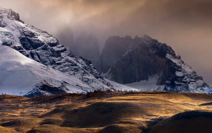 Snow-covered mountains and hills under misty sky