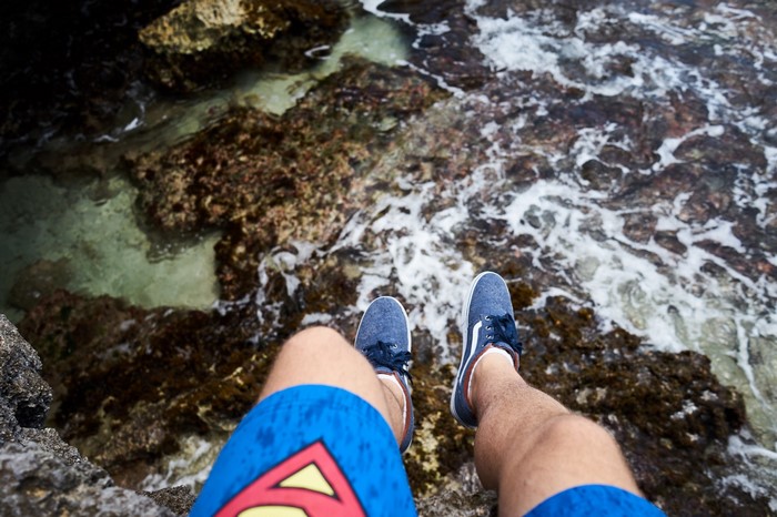 Person sitting on rocks by the sea