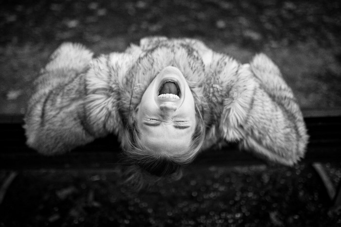 Woman in fur coat screaming upside down