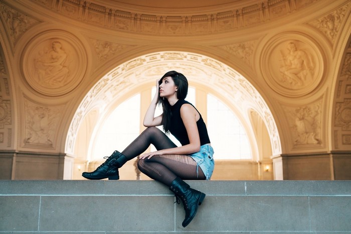 Stylish Woman Sitting with Boots and Denim Shorts