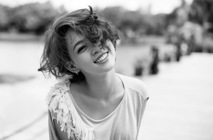 Monochrome portrait of a smiling Asian woman outdoors