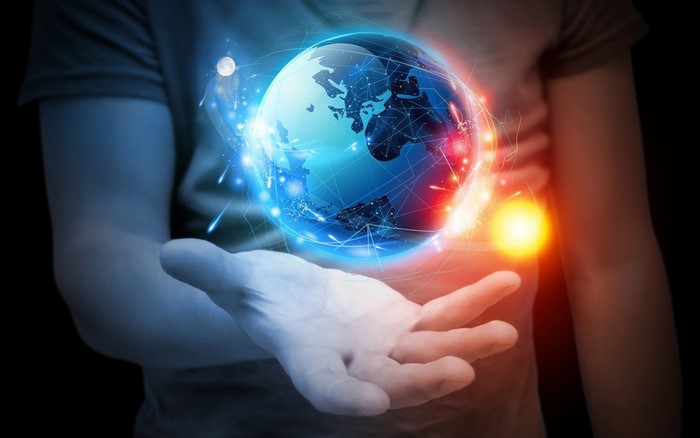Hand holding a glowing Earth with digital connections