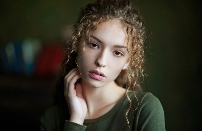 Portrait of a young woman with curly brown hair