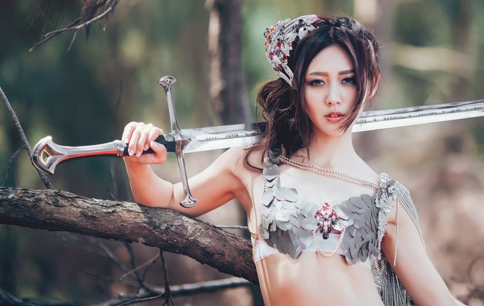 Asian woman in fantasy costume holding a sword