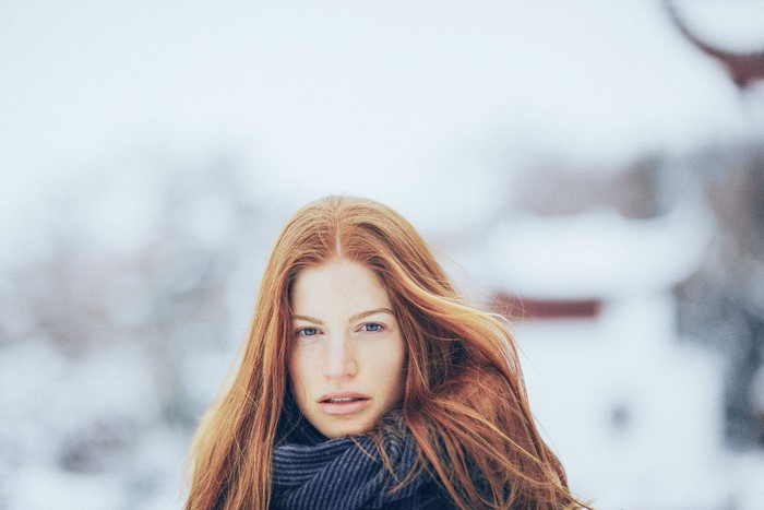 Woman with red hair and blue eyes in the snow