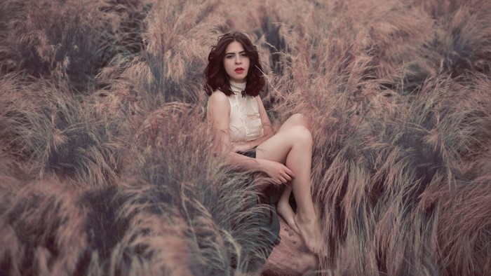 Woman sitting in a field of tall grass