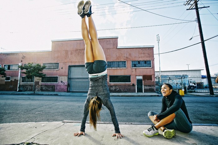 Two women exercising on a city street