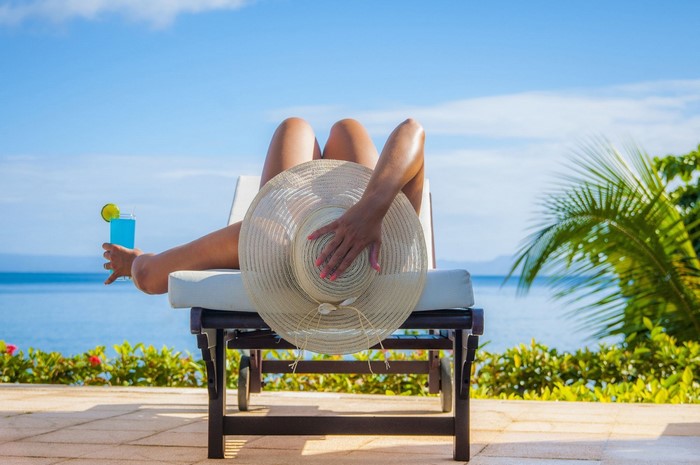 Woman relaxing on a lounge chair with a cocktail