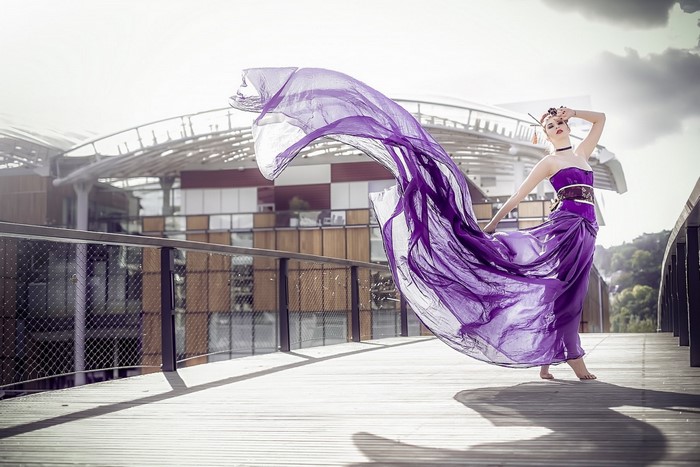 Woman in purple dress on a bridge