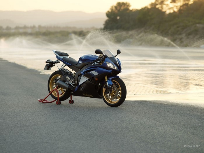 Blue Yamaha R6 motorcycle on a stand by the water