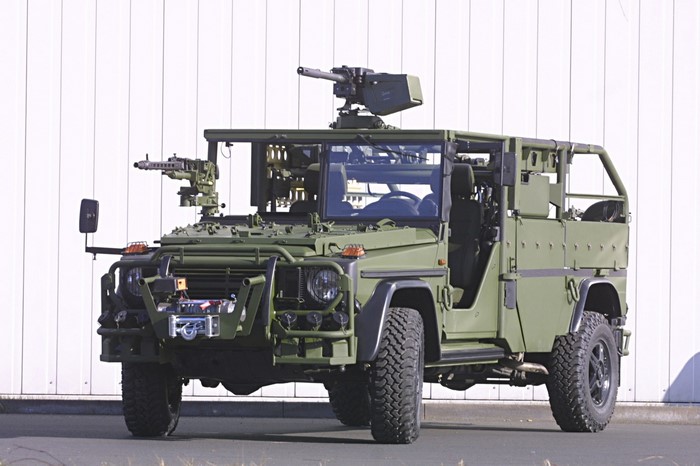 Green military vehicle with mounted machine guns