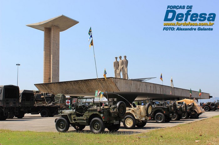 Military vehicles parked in front of a monument