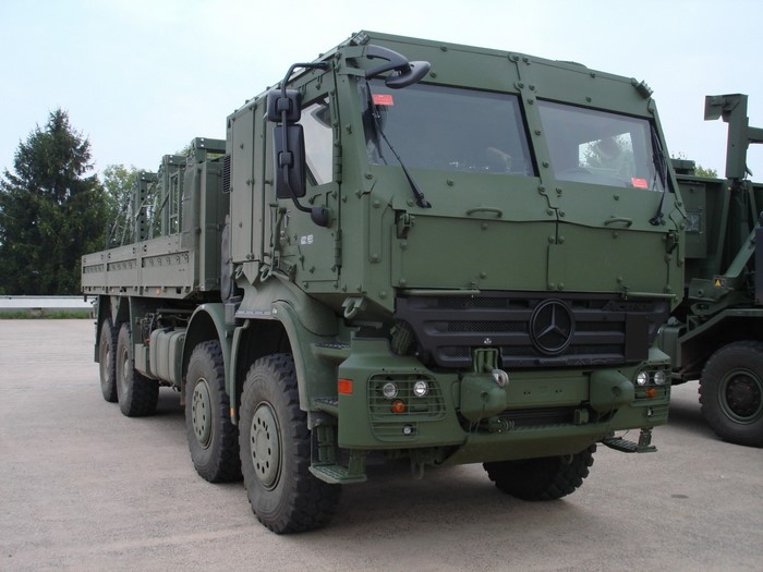 Green Mercedes-Benz military truck with flatbed