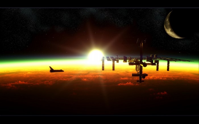 Space Shuttle and ISS above Earth's atmosphere at sunrise
