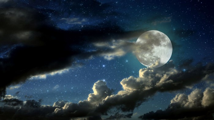 Full moon and clouds in a starry night sky