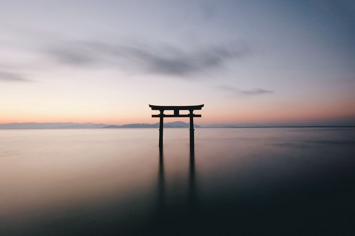 Torii gate in the sea at sunset