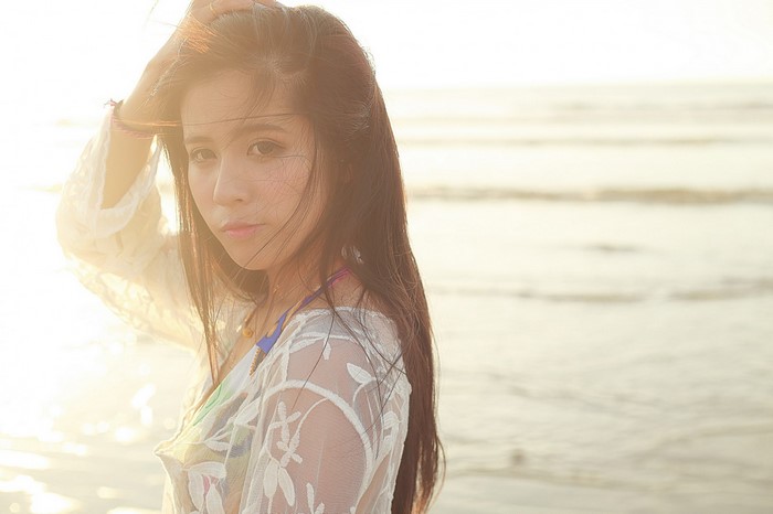 Woman with long hair on a beach at sunset