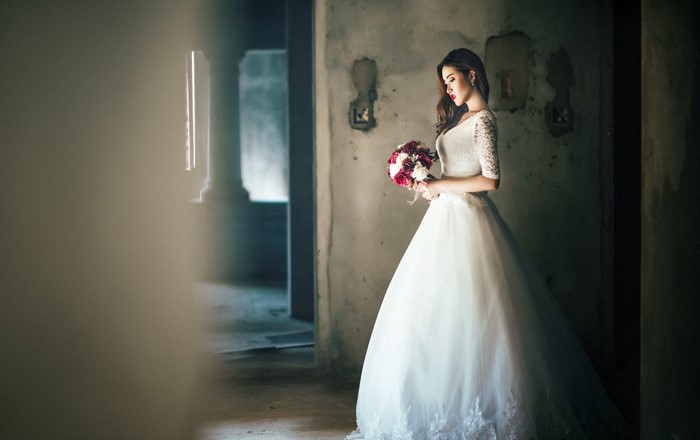 Elegant Bride in White Wedding Dress Holding Bouquet