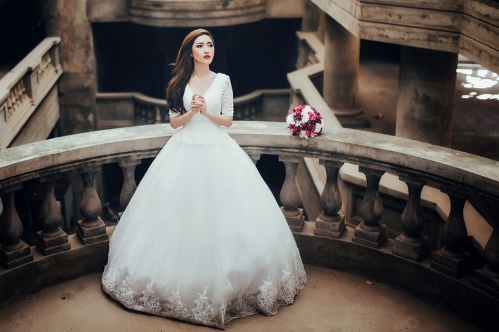 Bride in a white wedding dress holding hands