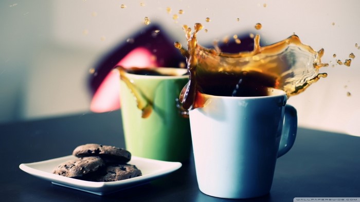 Coffee splash in cups with cookies