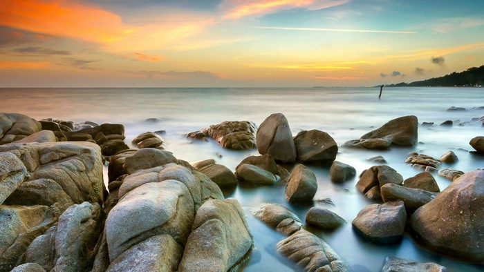 Rocky shore at sunset with ocean waves