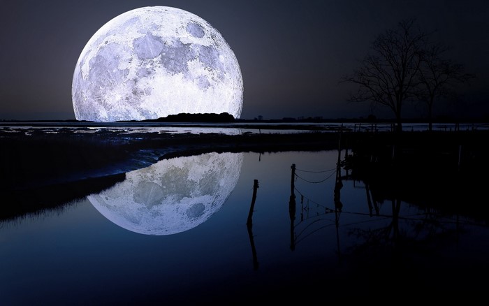 Full moon reflection over water at night