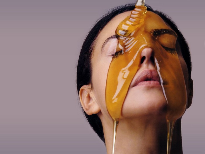 Woman with honey dripping on her face