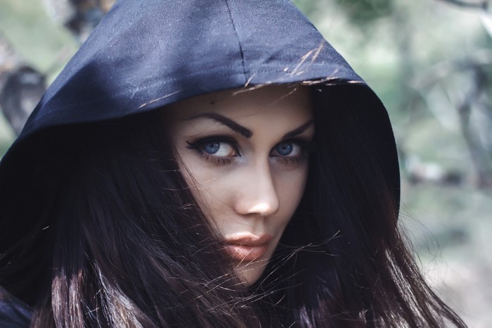 Woman with black hair and blue eyes wearing a hood