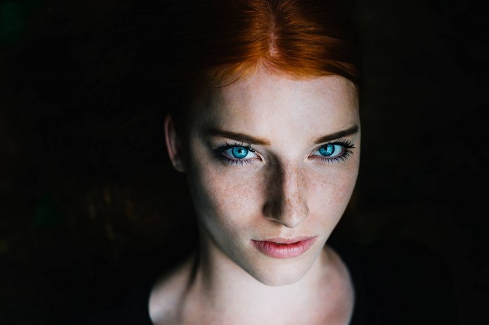Close up portrait of a redhead woman with blue eyes and freckles