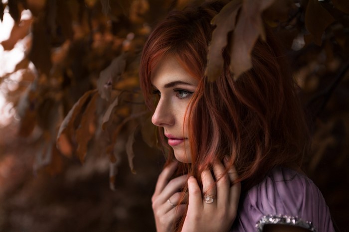 Redhead woman in profile with autumn leaves