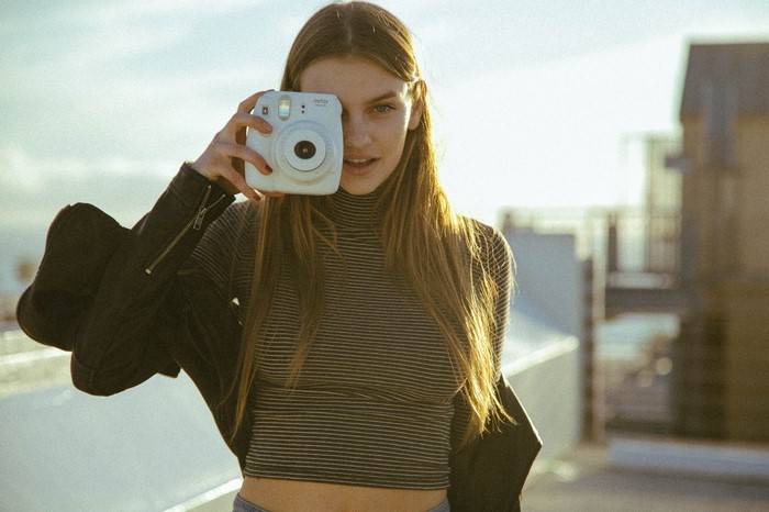 Woman holding Fujifilm Instax Mini 8 camera