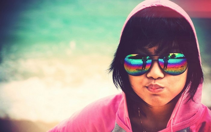 Girl wearing sunglasses with rainbow reflections