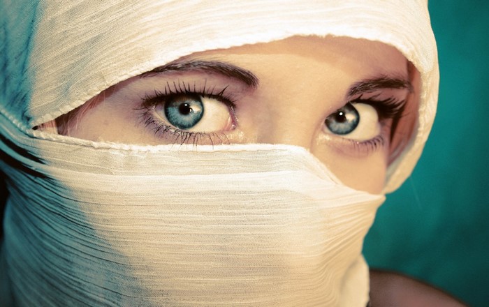 Close up of a woman's eyes covered by white fabric
