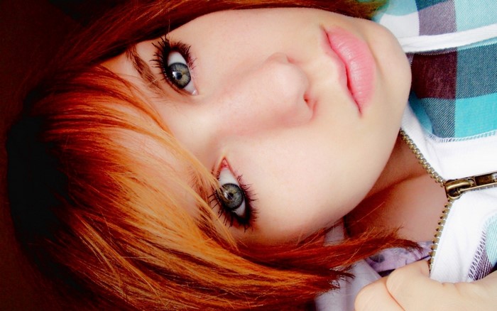 Close up of a young woman with red hair and blue plaid shirt
