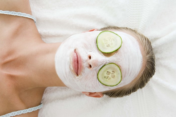 Woman with face mask and cucumber slices