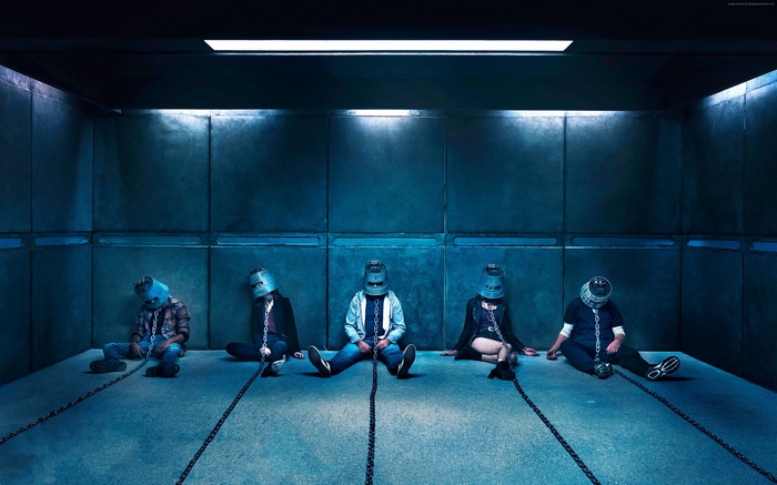 People in buckets chained in a dark room