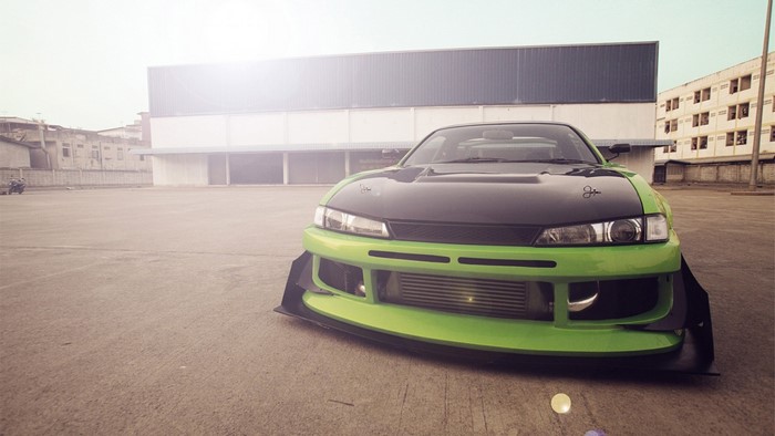 Modified green and black sports car in parking lot