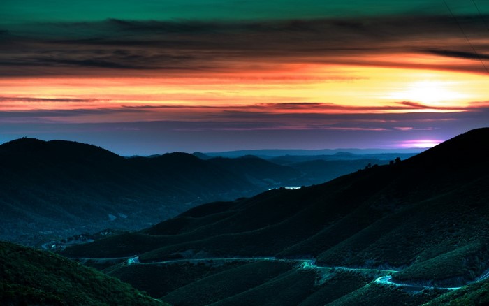 Mountain road at sunset with colorful sky