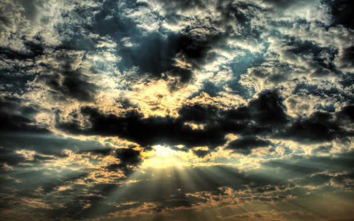 Sunlight beams through dark clouds at sunset