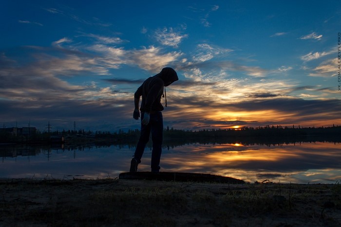 Silhouette of a person at sunset by the water