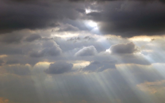 Sunlight breaking through dark storm clouds