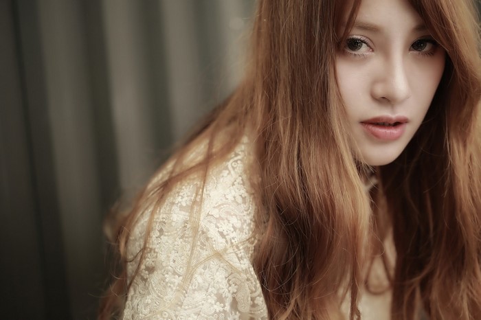 Close up portrait of a young Asian woman with long brown hair