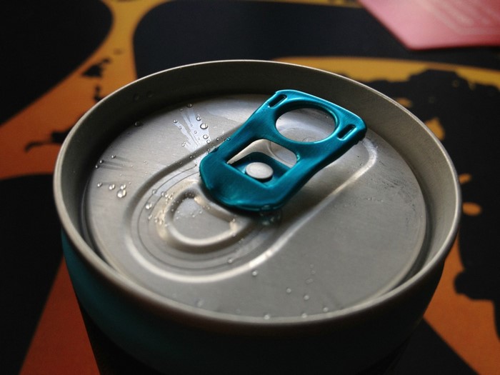 Close-up of a blue tab on a wet aluminum can