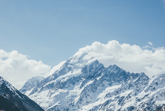 Snow-covered mountains under a blue sky with clouds