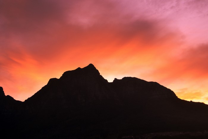Silhouette of mountains against a vibrant sunset sky