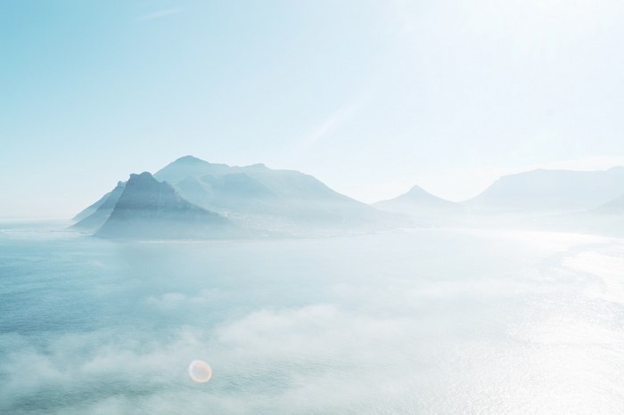 Misty mountains and sea under a bright sky