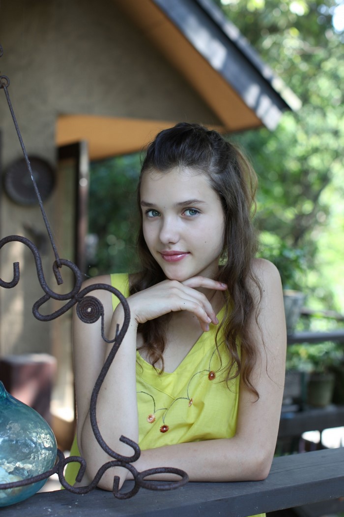 Young woman with brown hair in a yellow dress