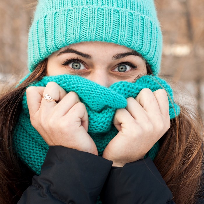 Woman wearing a teal beanie and scarf