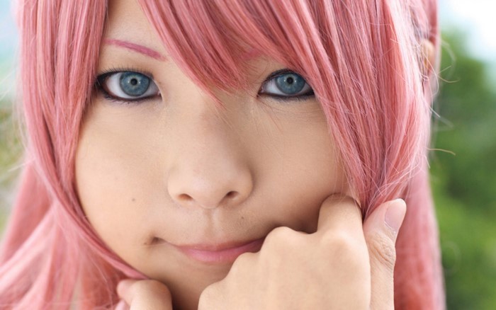 Close up of a woman with pink hair and blue eyes