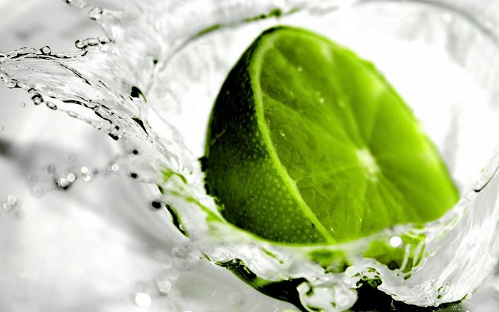 Close-up of a lime slice splashing into water